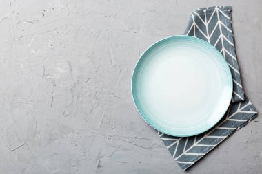 Renkli arkaplanda üst görünüm yiyecek için mavi tabak üzerinde boş. Tasarımınız için boşluk olan peçeteye boş tabak.