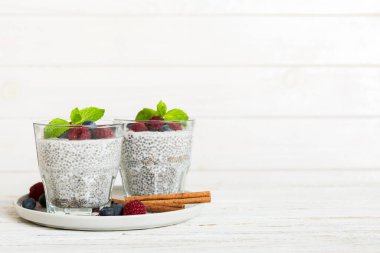 Sağlıklı kahvaltı ya da sabah chia tohumlu vanilyalı puding ahududu ve böğürtlen, vejetaryen gıda, diyet ve sağlık konsepti. Ahududu ve yabanmersinli Chia pudingi..