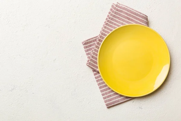 顶部的彩色背景空的圆形黄盘在桌布上为食物 餐巾上的空盘子 为您的设计留出空间 — 图库照片