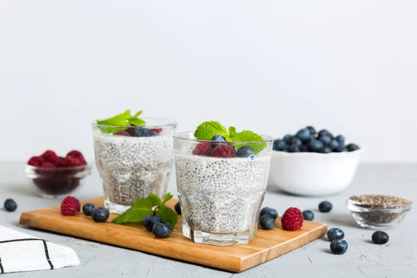 stock image Healthy breakfast or morning with chia seeds vanilla pudding raspberry and blueberry berries on table background, vegetarian food, diet and health concept. Chia pudding with raspberry and blueberry.