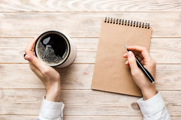 Frauenhand Mit Bleistift Auf Notizbuch Und Kaffeetasse Frau Arbeitet Bürotisch — Stockfoto