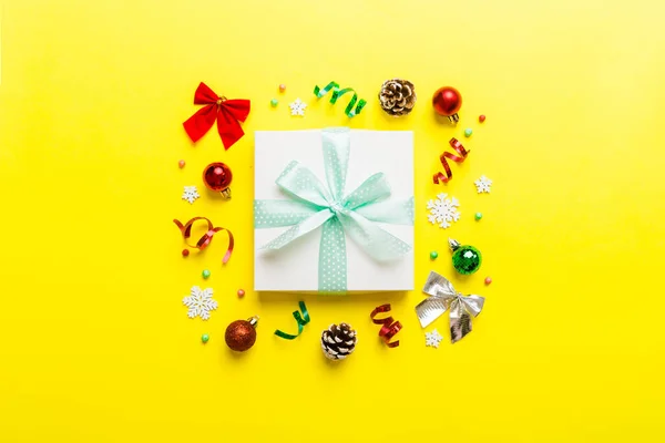 Top view Flat lay Christmas decorations and gift box on colored background with copy space. Christmas or Happy New Year composition.