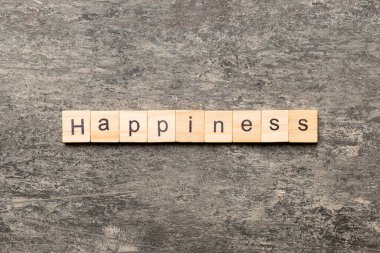 Tahta blokta yazan mutluluk kelimesi. Masada mutluluk metni, konsept.