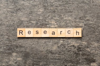 Tahta blokta yazan araştırma kelimesi. tablo üzerinde araştırma metni, konsept.
