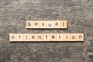 Tahta bloğa yazılmış cinsel yönelim kelimesi. Cinsel yönelim metniniz çimento üzerinde desing, kavram için.