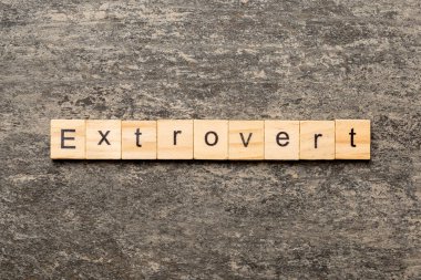 extrovert word written on wood block. extrovert text on table, concept. clipart