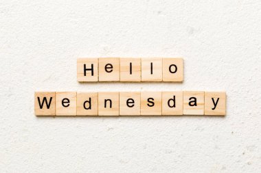 Merhaba çarşamba günü tahta blokta yazan kelime. Merhaba çarşamba günü çimento masasının üzerindeki yazı..