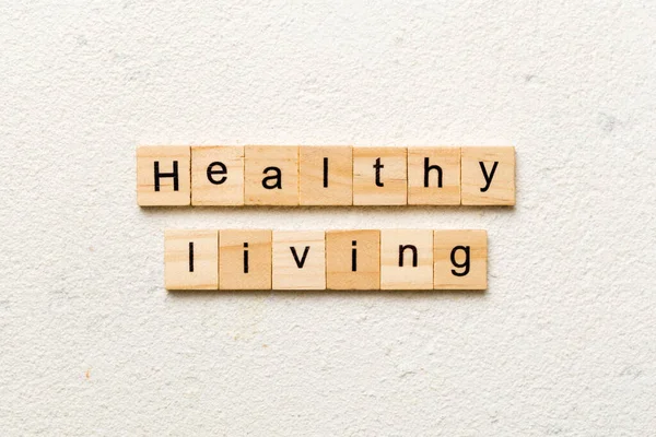 Healthy Living word written on wood block. Healthy Living text on cement table for your desing, concept.