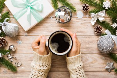 Elinde bir fincan kahve tutan kadın. Kadın elleri bardağı sıcak kahveyle tutuyor. Kış ve Noel zamanı kavramı.
