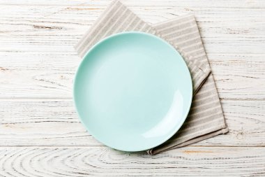 Renkli arkaplanda üst görünüm yiyecek için mavi tabak üzerinde boş. Tasarımınız için boşluk olan peçeteye boş tabak.