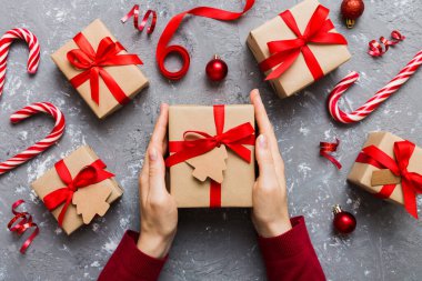 Kadın eli hediye kutusunu tutuyor, sürprizi hazırlıyor, üst manzara, Noel ve yeni yıl konsepti.