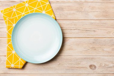 Renkli arkaplanda üst görünüm yiyecek için mavi tabak üzerinde boş. Tasarımınız için boşluk olan peçeteye boş tabak.