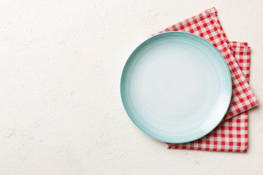 Renkli arkaplanda üst görünüm yiyecek için mavi tabak üzerinde boş. Tasarımınız için boşluk olan peçeteye boş tabak.