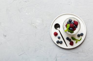 Sağlıklı kahvaltı ya da sabah chia tohumlu vanilyalı puding ahududu ve böğürtlen, vejetaryen gıda, diyet ve sağlık konsepti. Ahududu ve yabanmersinli Chia pudingi..