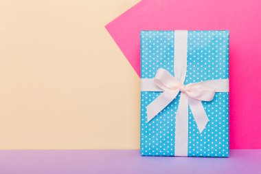 holiday handmade paper present tied white ribbon bow top view with copy space. Flat lay holiday background. Birthday or christmas present. Christmas gift box concept with copy space.