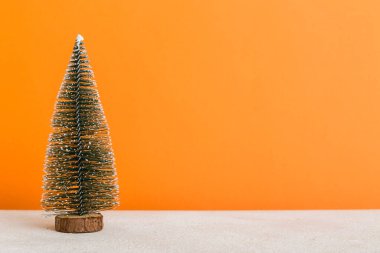 One small Christmas tree on colored background. new year decoration with copy space.