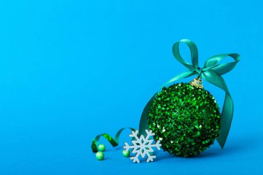 Christmas ball on colored background. decoration bauble with ribbon bow with copy space.