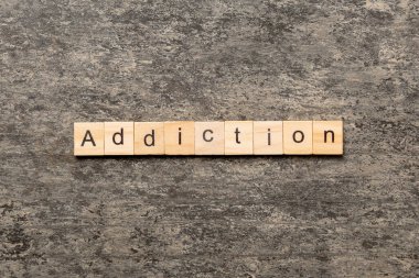 Addiction word written on wood block. Addictiontext on table, concept. clipart