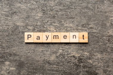 Tahta blokta ödeme kelimesi yazıyor. Ödeme metni desing için çimento tablo üzerinde konsept.