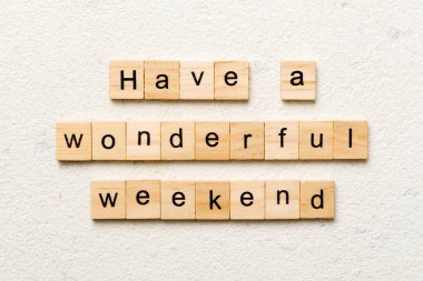 Have a wonderful weekend word written on wood block. Have a wonderful weekend text on cement table for your desing, Top view concept. clipart