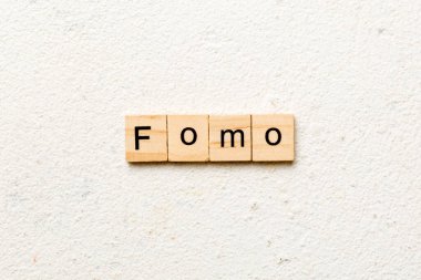 Tahta blokta yazılı bir kelime. fomo metin masa üzerinde, konsept.