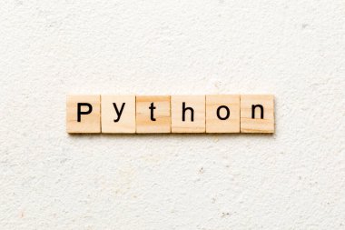 Tahta blokta piton kelimesi yazılı. Python metni tablo üzerinde, konsept.