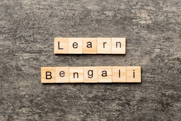learn Bengali word written on wood block. learn Bengali text on table, concept.