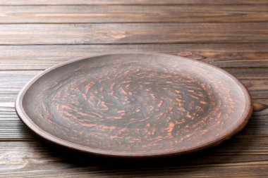 Ahşap zemindeki boş siyah plakanın perspektif görüntüsü. Tasarımın için boş boşluk.