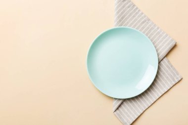 Renkli arkaplanda üst görünüm yiyecek için mavi tabak üzerinde boş. Tasarımınız için boşluk olan peçeteye boş tabak.