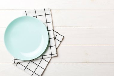 Renkli arkaplanda üst görünüm yiyecek için mavi tabak üzerinde boş. Tasarımınız için boşluk olan peçeteye boş tabak.