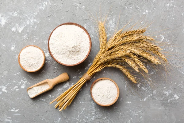 stock image Flat lay of Wheat flour in wooden bowl with wheat spikelets on colored background. world wheat crisis.