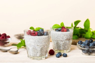 Sağlıklı kahvaltı ya da sabah chia tohumlu vanilyalı puding ahududu ve böğürtlen, vejetaryen gıda, diyet ve sağlık konsepti. Ahududu ve yabanmersinli Chia pudingi..