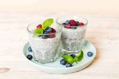 Sağlıklı kahvaltı ya da sabah chia tohumlu vanilyalı puding ahududu ve böğürtlen, vejetaryen gıda, diyet ve sağlık konsepti. Ahududu ve yabanmersinli Chia pudingi..