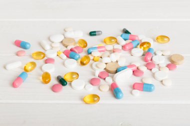 Çeşitli ilaç ve haplardan oluşan bir koleksiyon. Masa arkasında çeşitli ilaç hapları, haplar ve kapsüller var. Çeşitli ilaç tabletleri yığını. Sağlık hizmetleri.