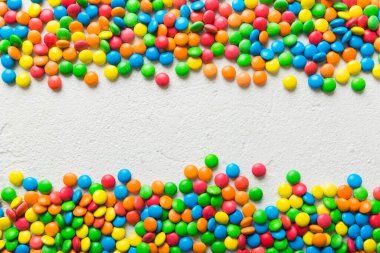 Renkli arka planda karışık renkli şeker koleksiyonu. Düz yerde, üst tarafta. Renkli çikolata kaplı şeker çerçevesi.