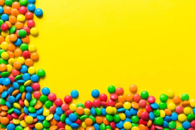 Renkli arka planda karışık renkli şeker koleksiyonu. Düz yerde, üst tarafta. Renkli çikolata kaplı şeker çerçevesi.