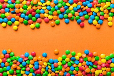 Renkli arka planda karışık renkli şeker koleksiyonu. Düz yerde, üst tarafta. Renkli çikolata kaplı şeker çerçevesi.