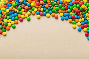 Renkli arka planda karışık renkli şeker koleksiyonu. Düz yerde, üst tarafta. Renkli çikolata kaplı şeker çerçevesi.