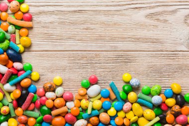 Renkli arka planda karışık renkli şeker koleksiyonu. Düz yerde, üst tarafta. Renkli çikolata kaplı şeker çerçevesi.
