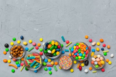 farklı renkte yuvarlak şekerler ve kavanozlar. Fotokopi alanı olan büyük çeşitlilikteki şeker ve şekerlerin üst görünümü.
