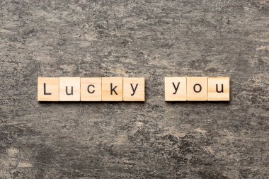Lucky you word written on wood block. Lucky you text on table for your desing, Top view concept.