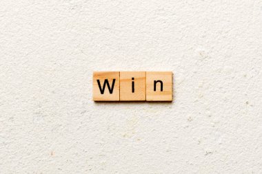 Tahta blokta yazılı bir kelime. Deksing, konsept için çimento masadaki WIN metni.
