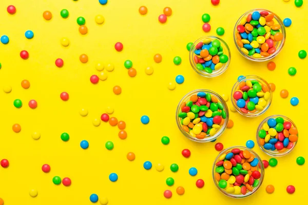 ボウルと瓶の中の色の違う丸いキャンディー コピースペース付きの大規模な様々なお菓子やキャンディーのトップビュー — ストック写真