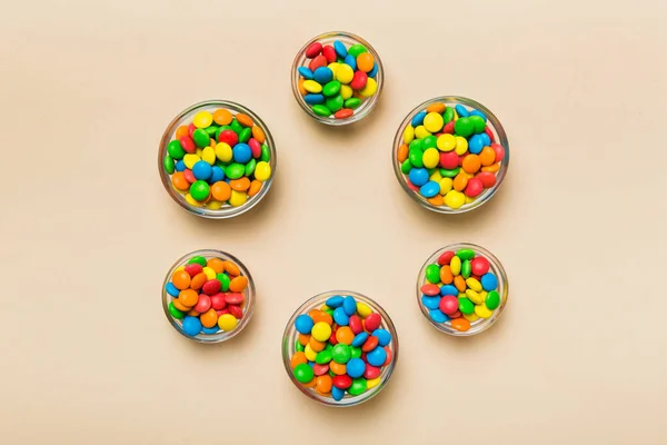 stock image different colored round candy in bowl and jars. Top view of large variety sweets and candies with copy space.