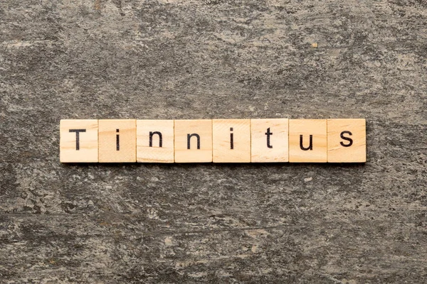 Tinnitus Słowo Napisane Bloku Drewna Tinnitus Tekst Stole Cementowym Projektowania — Zdjęcie stockowe