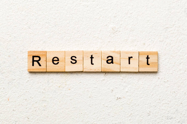 restart word written on wood block. restart text on table, concept.