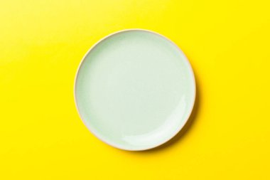 Renkli arka planın üst görüntüsü yiyecek için boş mavi tabak. Tasarımınız için alanı olan boş tabak.