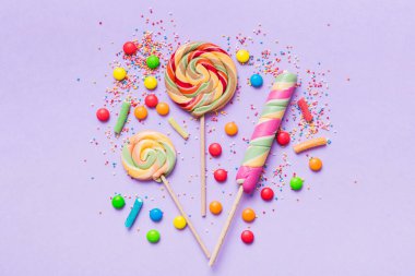 Lezzetli İştah açıcı Parti Aksesuarları Mutlu Yıllar Tatlı. Renkli arkaplanda farklı tipte şekerler, kopyalama alanı. Renkli doğum günü partisi geçmişi.