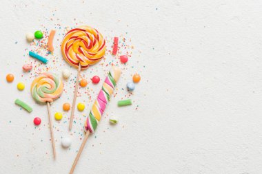 Lezzetli İştah açıcı Parti Aksesuarları Mutlu Yıllar Tatlı. Renkli arkaplanda farklı tipte şekerler, kopyalama alanı. Renkli doğum günü partisi geçmişi.