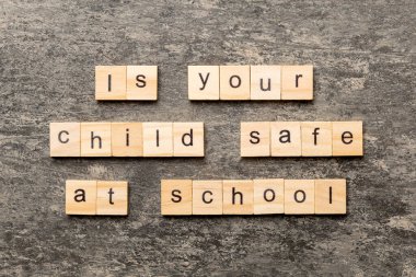 Çocuğun okul dilinde tahta blokta yazarken güvende mi? Çocuğun çimento masadaki okul metninde güvende mi? Top view konseptin için..